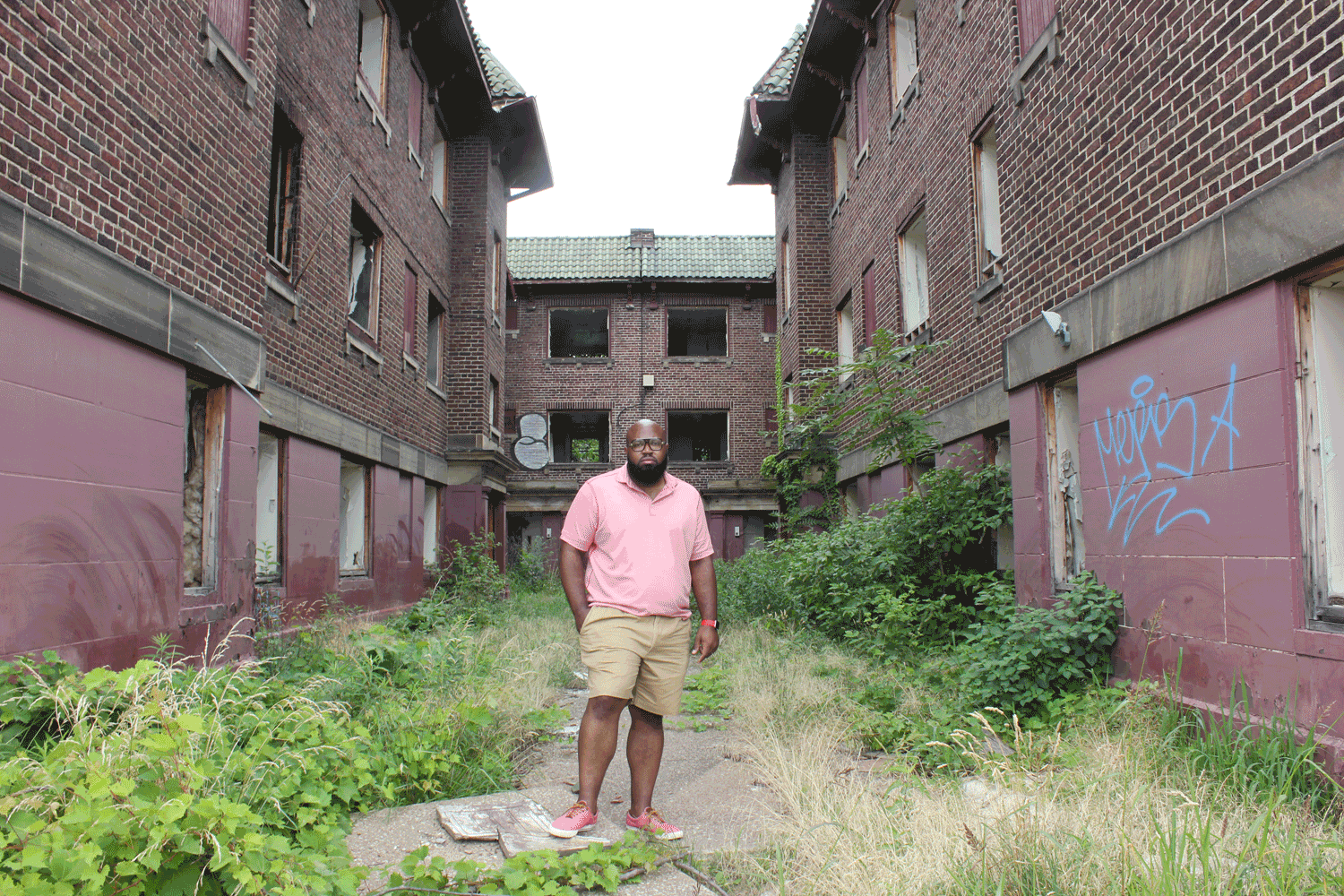 Darius Steward stands in front off an abandoned apartment building on Page Avenue in East Cleveland, where he grew up. His childhood home, a building that once stood across the street, has since been torn down.